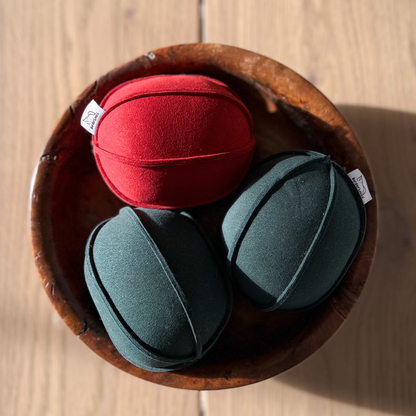 3 dog toys in a bowl - 2 green and 1 red suede balls