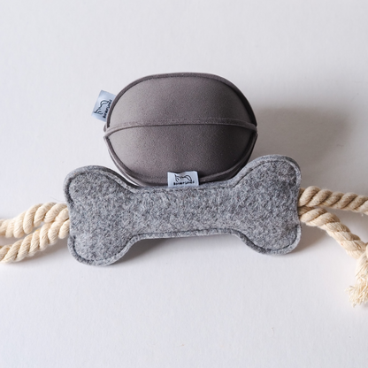 Grey suede indoor dog toy ball along side light grey felt and cotton rope toy dog toy