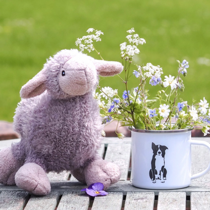 Enamel Border Collie Design mug outside sitting next to plush lamb squeaky dog toy both by Border Loves