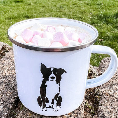 Enamel border collie camper mug shown outside and containing hot chocolate mug by Border Loves with Border Collie on the front